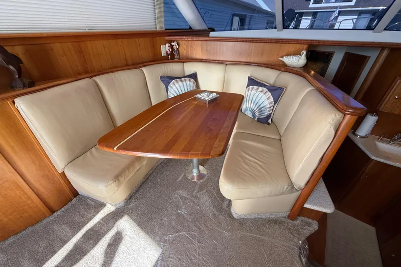 Slide: The Image of Luxurious interior of 2001 Silverton 42 Convertible yacht with plush seating and wooden table. - 34