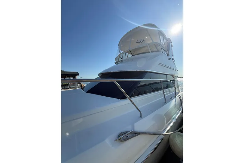 Slide: The Image of 2001 Silverton 42 Convertible yacht with sleek design under clear blue sky. - 4