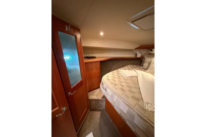 Slide: The Image of Cozy bedroom interior of 2001 Silverton 42 Convertible yacht with wooden door and bedding. - 41