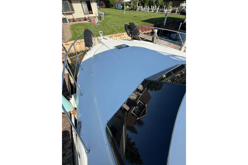 Slide: The Image of 2001 Silverton 42 Convertible yacht docked, showcasing sleek deck and waterfront setting. - 6