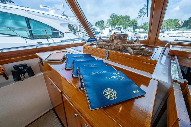 Slide: The Image of Interior of 2004 Grand Banks 49 Eastbay HX with ship's logs on wooden table. - 15