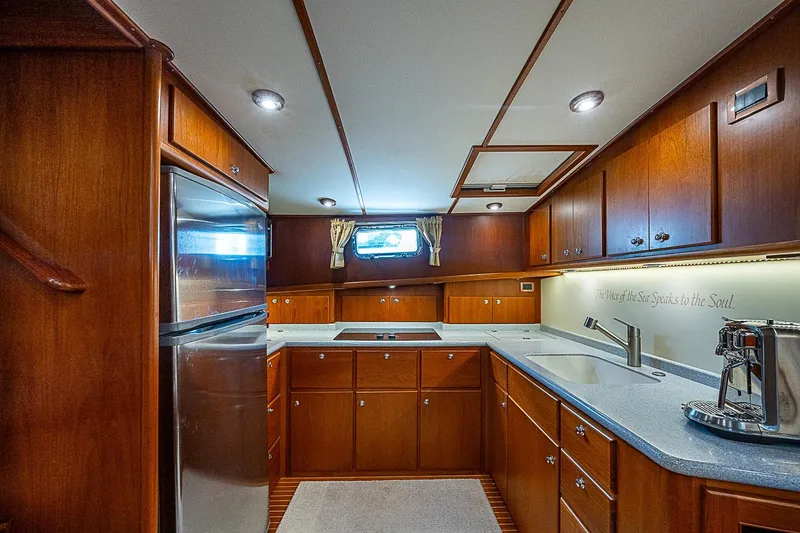 Slide: The Image of Luxurious 2004 Grand Banks 49 Eastbay HX yacht kitchen with wood cabinetry and modern appliances. - 23