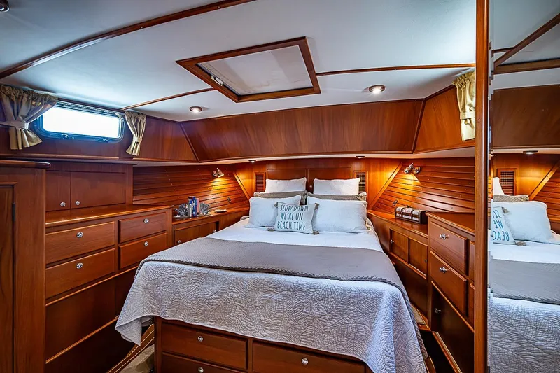 Slide: The Image of Luxurious 2004 Grand Banks 49 Eastbay HX yacht cabin with elegant wood finish and cozy bedding. - 25