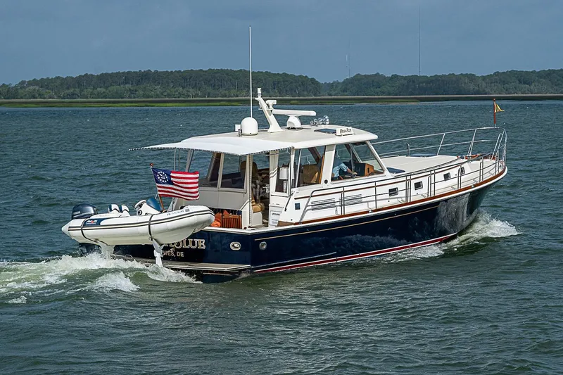 Slide: The Image of 2004 Grand Banks 49 Eastbay HX cruising on open water with American flag. - 3