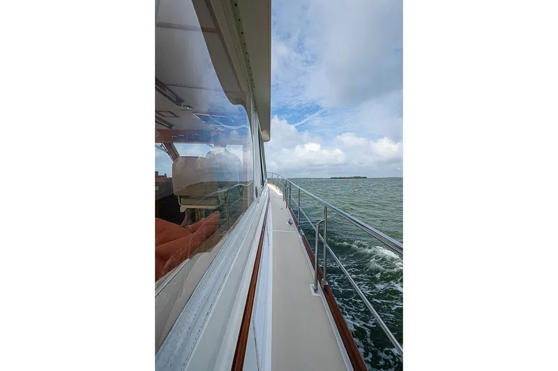 Slide: The Image of Side view of 2004 Grand Banks 49 Eastbay HX yacht cruising on open water. - 36
