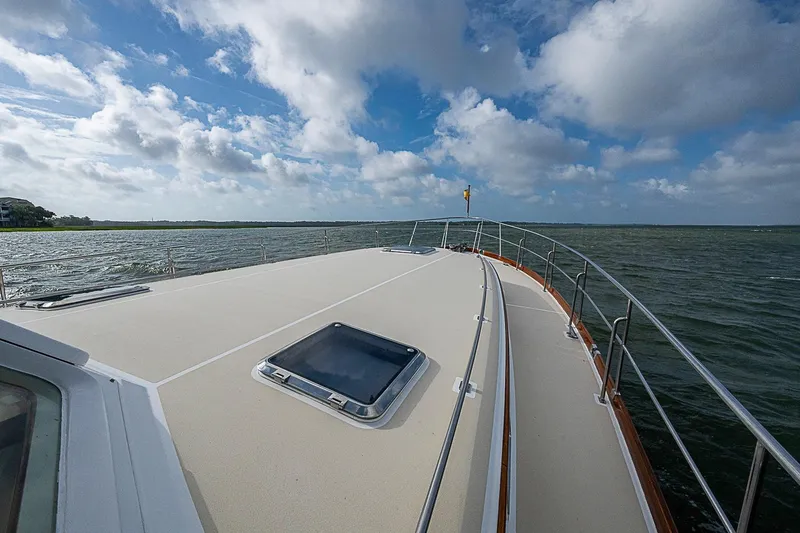 Slide: The Image of 2004 Grand Banks 49 Eastbay HX yacht deck with ocean view under cloudy sky. - 37