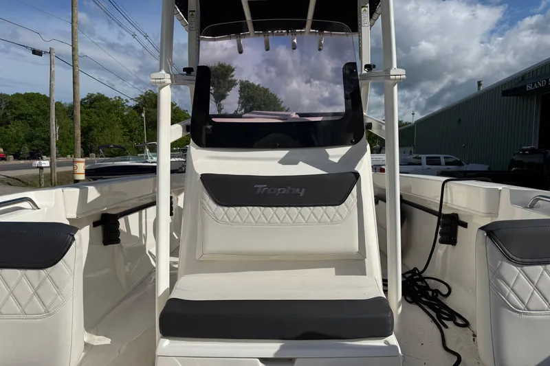 Slide: The Image of 2021 Trophy T22CX boat interior with seating and console, under a partly cloudy sky. - 11