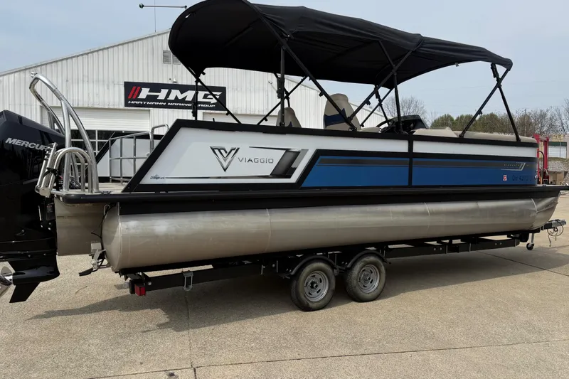 Slide: The Image of 2022 Viaggio Diamante S 26 pontoon boat with canopy on trailer, parked outside. - 5