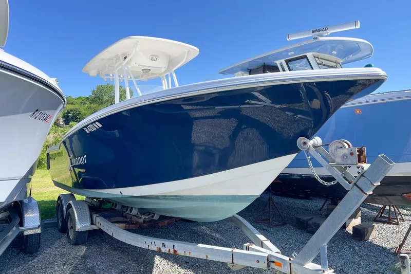 The Image of 2013 Tidewater 230 CC Adventure boat on trailer under clear blue sky. - 1