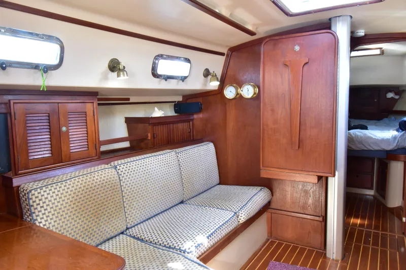 Slide: The Image of Interior of 1995 Island Packet 37 sailboat with wooden furnishings and cozy seating area. - 10