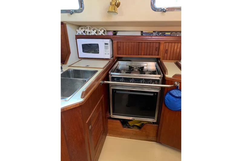 Slide: The Image of Compact galley kitchen in 1995 Island Packet 37 sailboat with stove, microwave, and sink. - 13