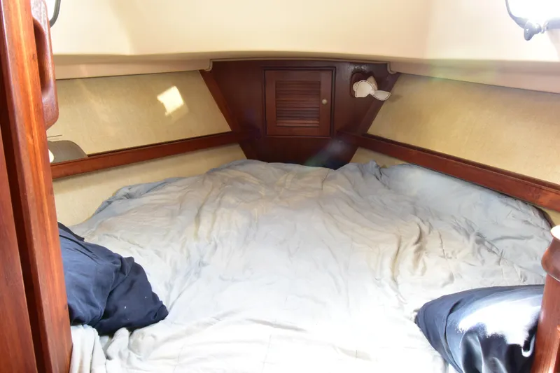 Slide: The Image of Cozy cabin interior of 1995 Island Packet 37 sailboat with bedding and wooden accents. - 15