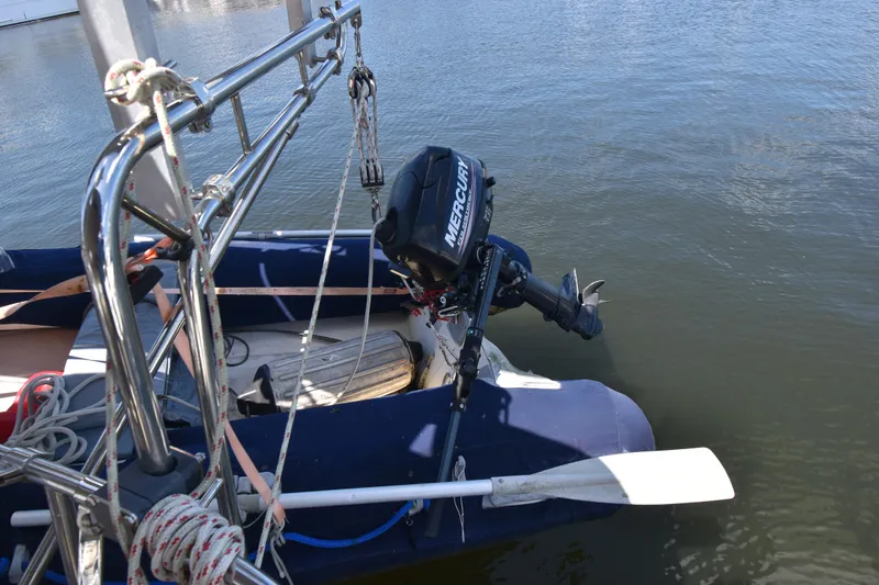 Slide: The Image of 1995 Island Packet 37 sailboat with Mercury outboard motor on calm water. - 19