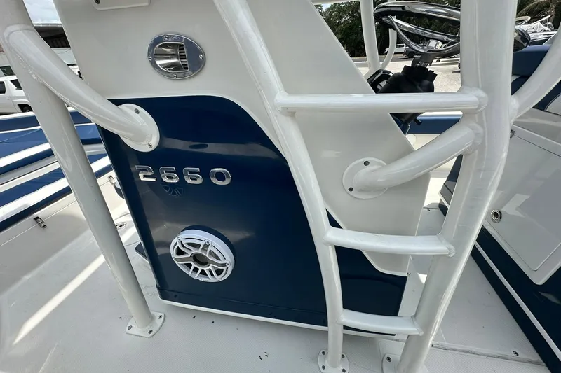 Slide: The Image of 2026 Ranger 2660 Bay boat console with blue and white design, featuring speaker and ladder. - 19