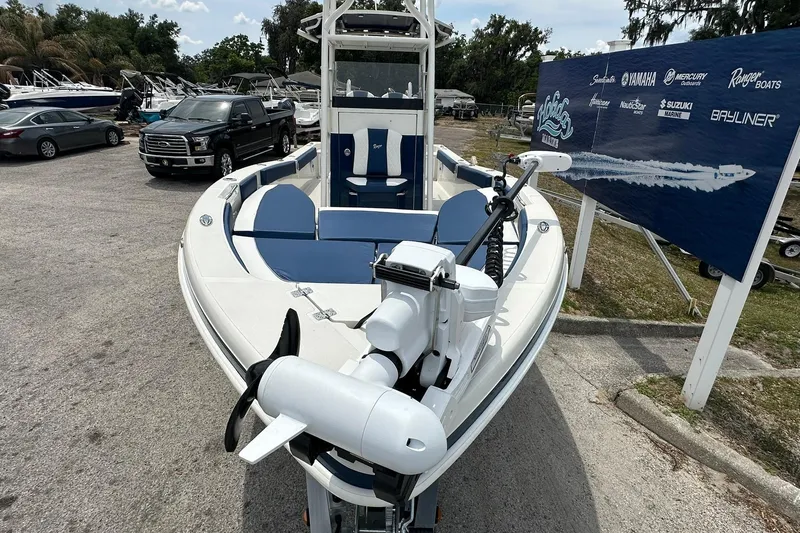 Slide: The Image of 2026 Ranger 2660 Bay boat displayed outdoors with blue seating and motor. - 2
