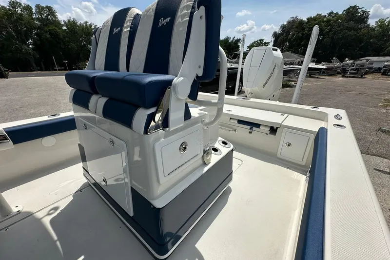 Slide: The Image of 2026 Ranger 2660 Bay boat interior with blue and white seating, docked outdoors. - 20