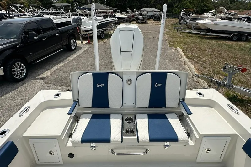 Slide: The Image of 2026 Ranger 2660 Bay boat interior with blue and white seating, parked outdoors. - 32