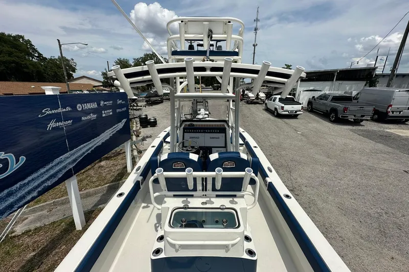 Slide: The Image of 2026 Ranger 2660 Bay boat with fishing rod holders and navigation equipment, parked outdoors. - 36