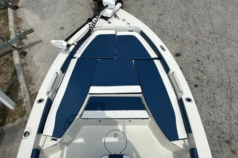 Slide: The Image of 2026 Ranger 2660 Bay boat with blue and white seating, docked on pavement. - 41