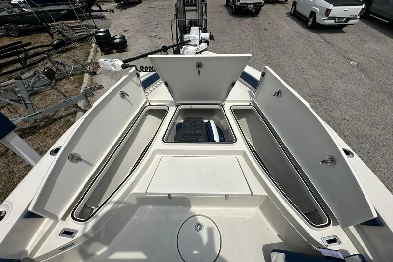 Slide: The Image of 2026 Ranger 2660 Bay boat with open storage compartments, parked on a trailer. - 7