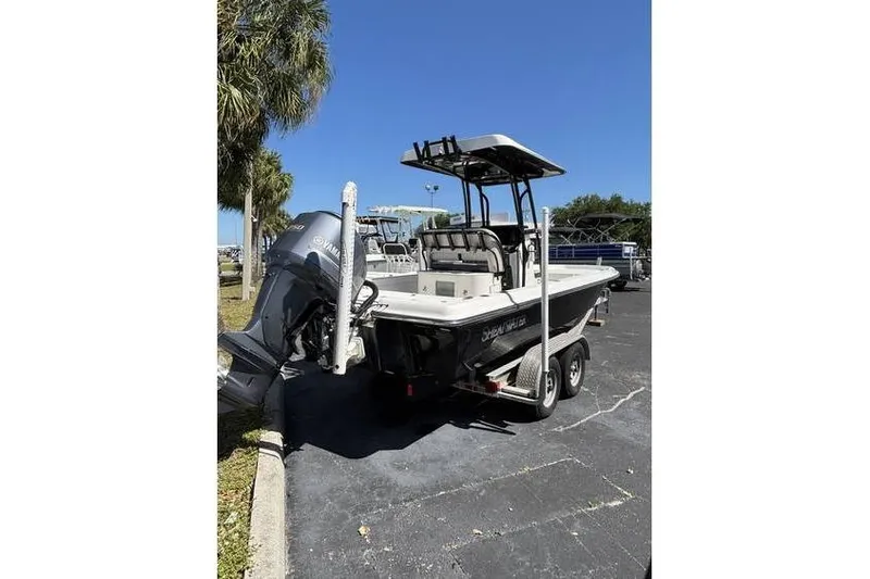 Slide: The Image of 2018 ShearWater 25 LTD boat on trailer, parked outdoors under clear blue sky. - 12