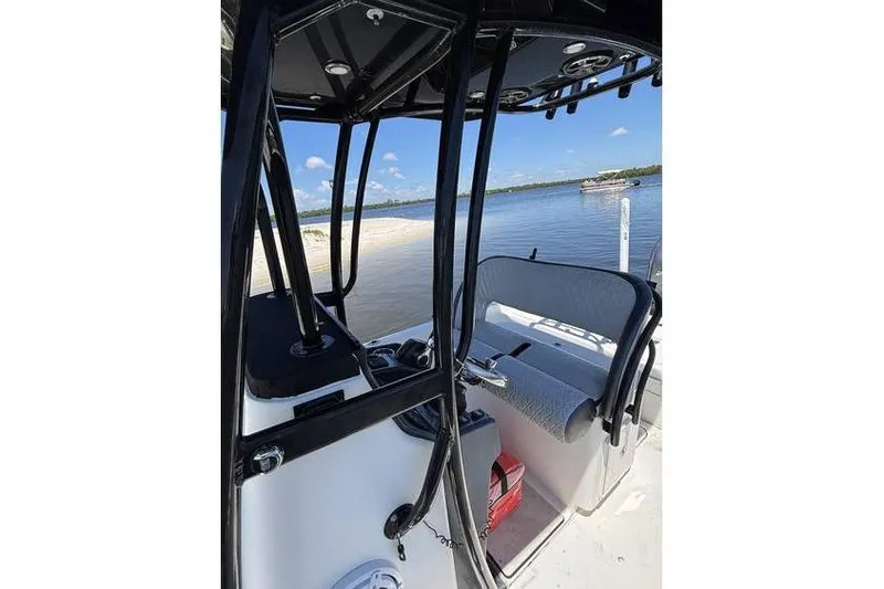 Slide: The Image of 2018 ShearWater 25 LTD boat interior with seating, near sandy shore and calm water. - 14
