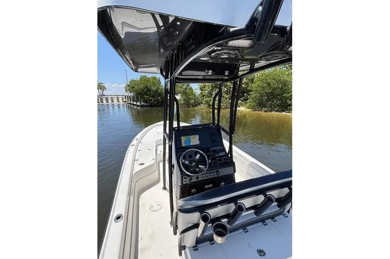 Slide: The Image of 2018 ShearWater 25 LTD boat with sleek console and canopy on calm water. - 5