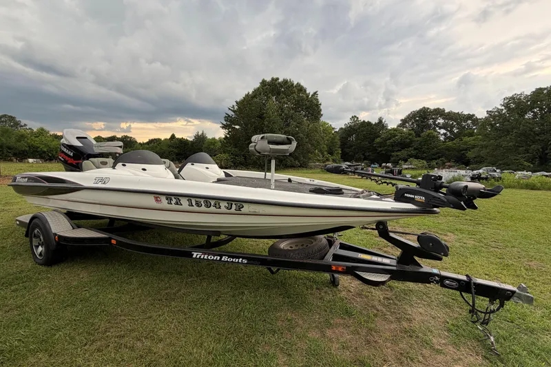 Slide: The Image of 2001 Triton Tr-19 boat on trailer, parked on grass under cloudy sky. - 2