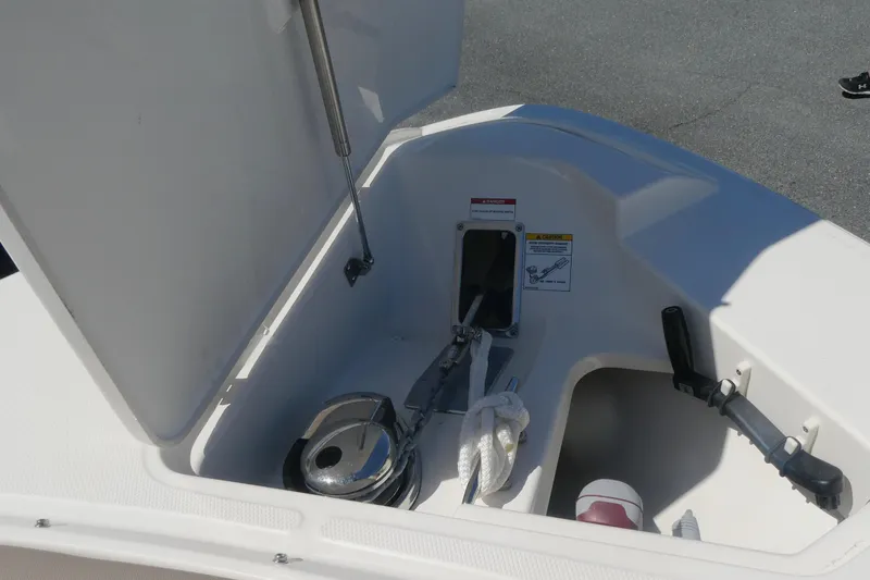 Slide: The Image of Open storage compartment on 2026 Boston Whaler 330 Vantage boat, featuring anchor and rope. - 14