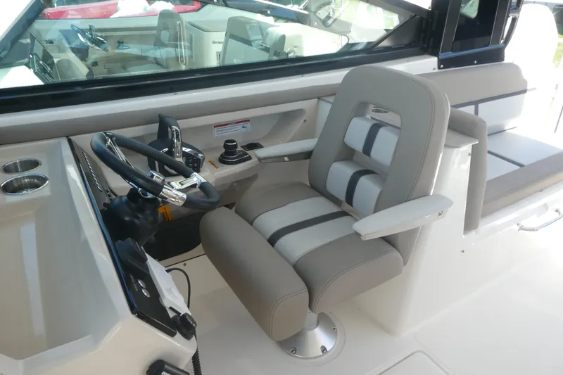 Slide: The Image of 2026 Boston Whaler 330 Vantage helm with modern steering and comfortable seating. - 16