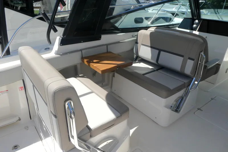 Slide: The Image of 2026 Boston Whaler 330 Vantage interior with seating and wooden table. - 7