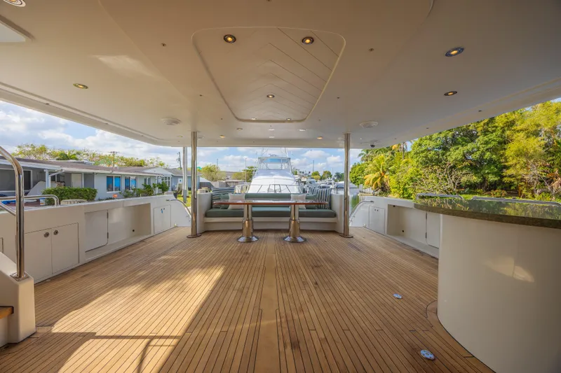 Slide: The Image of Luxurious 2011 Westport 112 yacht deck with seating, wooden flooring, and scenic view. - 2