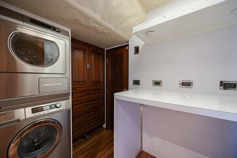 Slide: The Image of Laundry room in a 2011 Westport 112 yacht with stacked washer and dryer. - 52