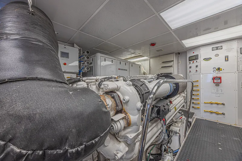 Slide: The Image of Engine room of a 2011 Westport 112 yacht, featuring machinery and control panels. - 65
