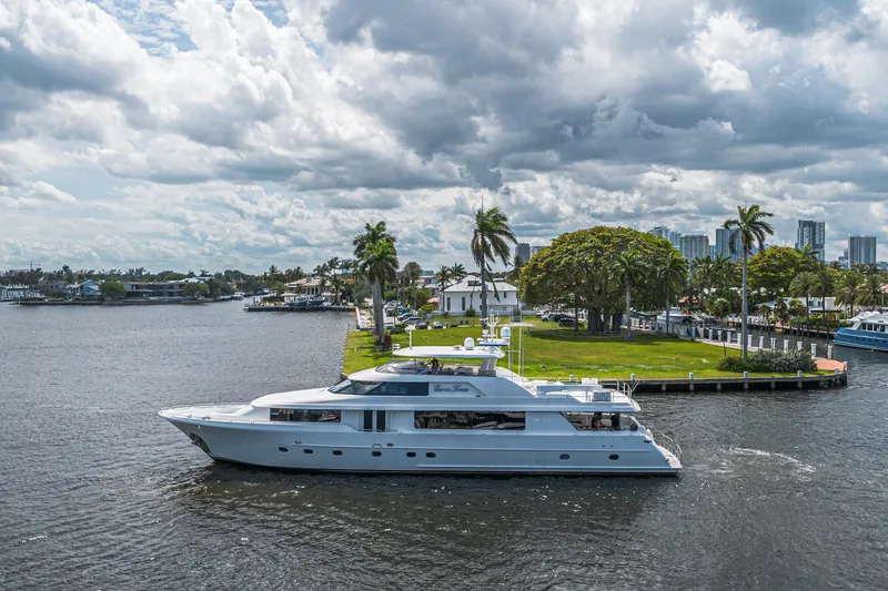 Slide: The Image of Luxurious 2011 Westport 112 yacht cruising near a lush, palm-lined waterfront. - 72