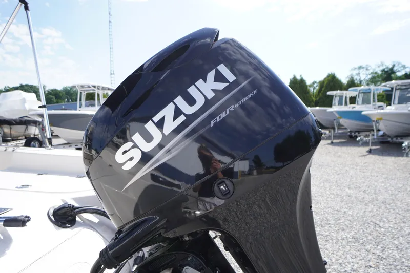 Slide: The Image of Suzuki four-stroke engine on 2024 Carolina Skiff 182 boat, parked outdoors. - 10