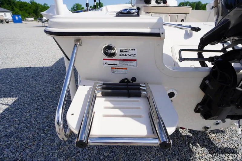 Slide: The Image of 2024 Carolina Skiff 182 boat with rear swim ladder and safety labels. - 13