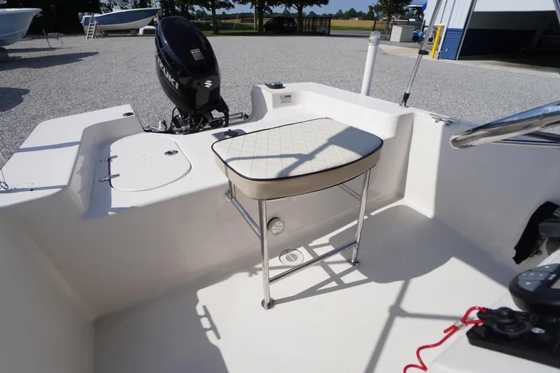 Slide: The Image of 2024 Carolina Skiff 182 boat interior with seating and Suzuki outboard motor. - 20