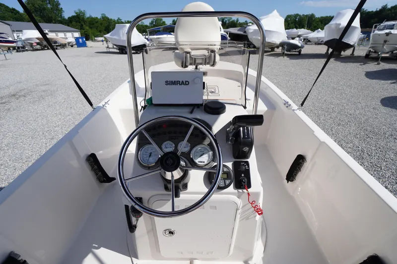 Slide: The Image of 2024 Carolina Skiff 182 boat dashboard with steering wheel and Simrad navigation system. - 21