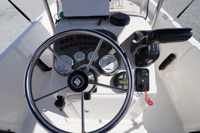 Slide: The Image of 2024 Carolina Skiff 182 boat dashboard with steering wheel and control panel. - 22