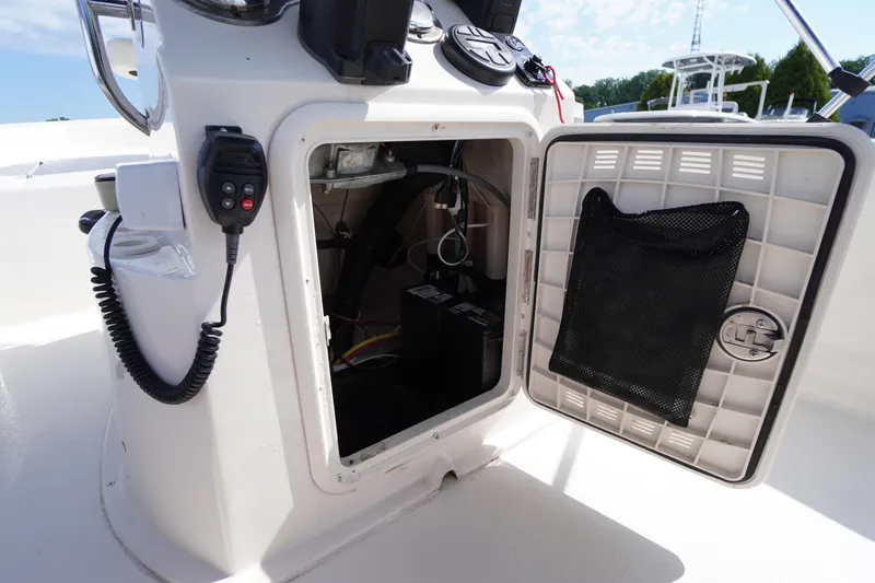 Slide: The Image of 2024 Carolina Skiff 182 boat console with open storage compartment and control panel. - 28