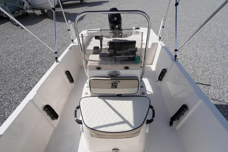 Slide: The Image of 2024 Carolina Skiff 182 boat interior with seating and console, on gravel surface. - 31