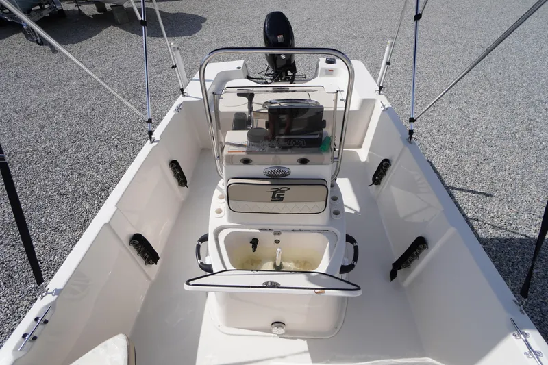 Slide: The Image of 2024 Carolina Skiff 182 boat interior with console and seating, on gravel surface. - 32
