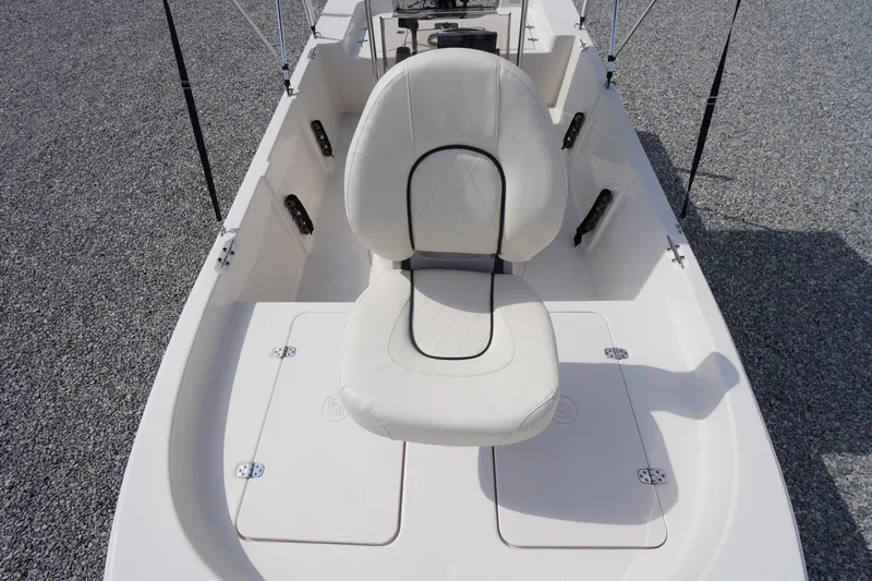 Slide: The Image of 2024 Carolina Skiff 182 boat interior with white cushioned seat and storage compartments. - 36