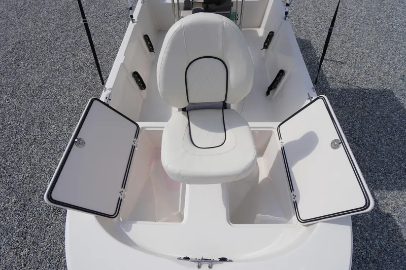Slide: The Image of 2024 Carolina Skiff 182 boat interior with white seating and open storage compartments. - 37