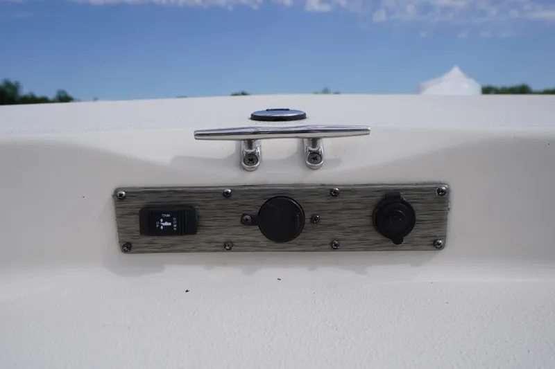 Slide: The Image of 2024 Carolina Skiff 182 boat control panel with switches and cleat against blue sky. - 40