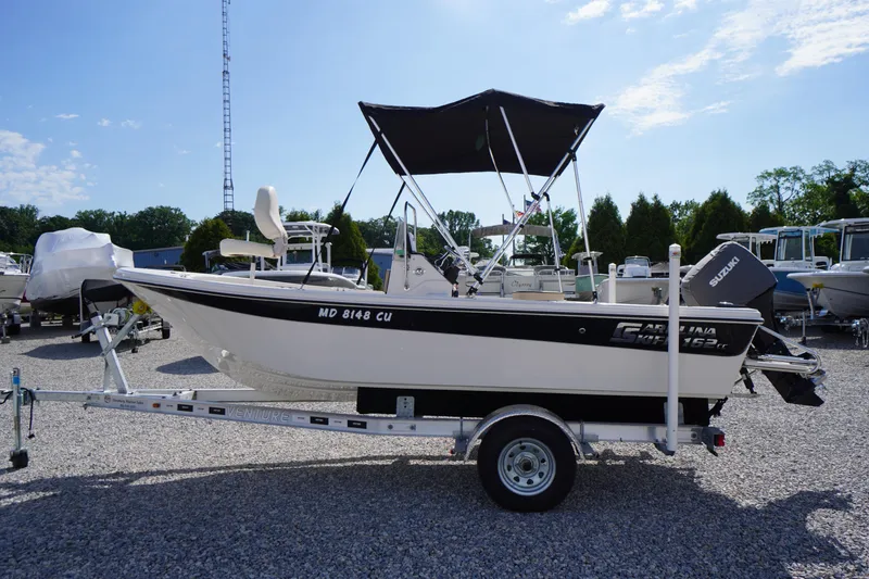Slide: The Image of 2024 Carolina Skiff 182 boat on trailer with Suzuki outboard motor. - 6