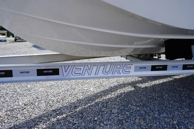 Slide: The Image of 2024 Carolina Skiff 182 boat on Venture trailer, parked on gravel. - 7