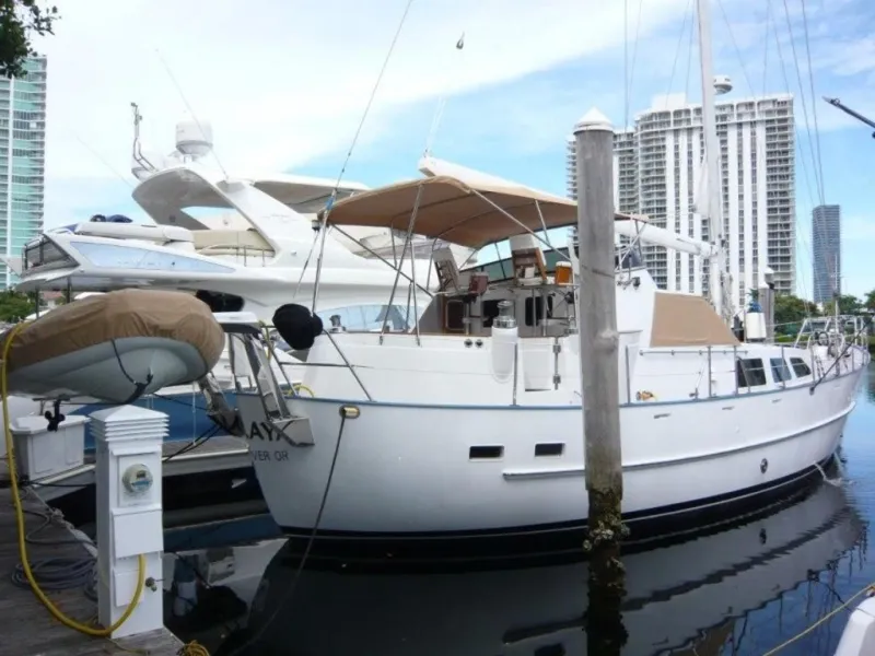 Slide: The Image of 1990 Cheoy Lee Sloop docked at marina with cityscape background. - 3