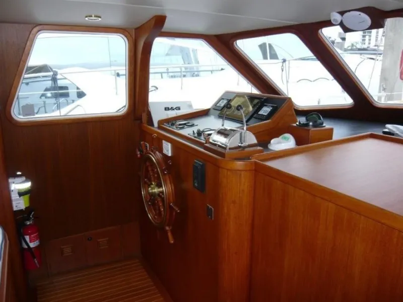 Slide: The Image of 1990 Cheoy Lee Sloop interior helm with wooden finish and navigation equipment. - 31